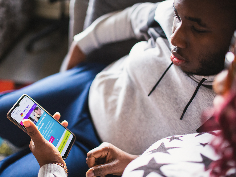 a teenager and his mum looking at the family fund website on a smartphone