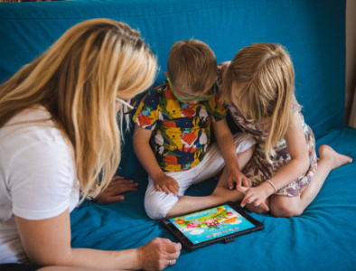 Family sitting on a sofa using a tablet