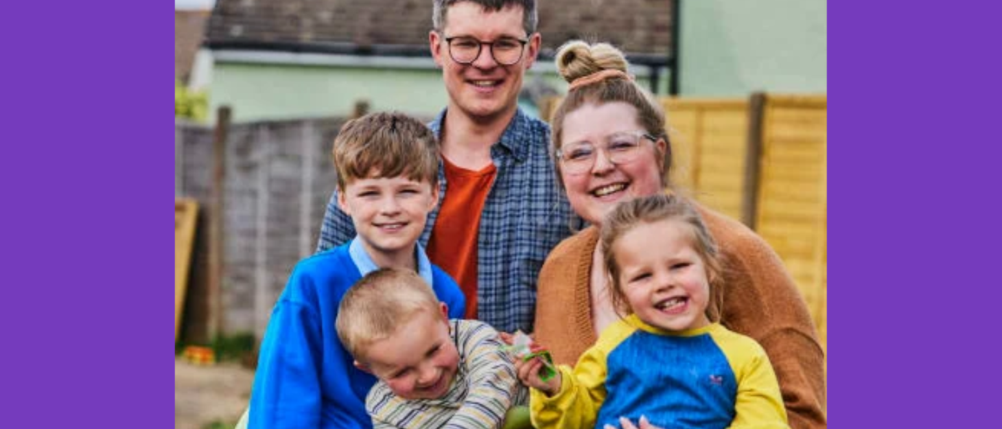 A family (mum, dad, two brothers and a sister) smile together in their garden